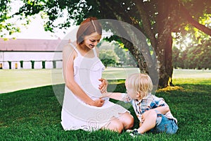 Pregnant woman with child on nature.