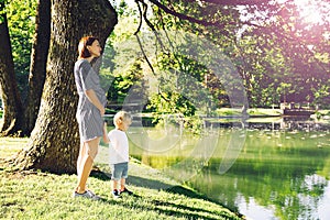 Pregnant woman with child outdoors.