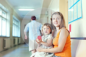 Pregnant woman and child with urinalysis sample photo