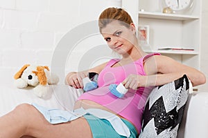 Pregnant woman with children's clothes.