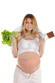 Pregnant woman with chocolate and lettuce