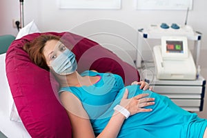 Pregnant woman in clinic wearing face mask