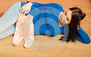 Pregnant woman with clothes for unborn baby