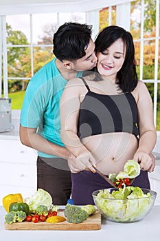 Pregnant woman cooking with her husband