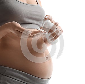 Pregnant woman with cosmetic product on white background, closeup