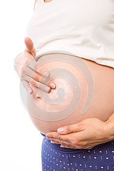 Pregnant woman with cream on bump
