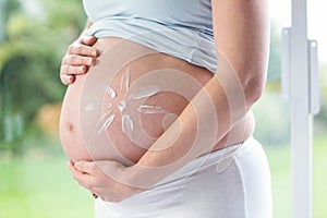 Pregnant woman with cream on her belly