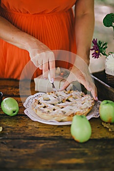 Pregnant woman cutting home-made apple pie