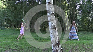 Pregnant woman with daughter girl play badminton game in park