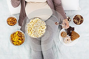 Pregnant woman devouring tasty junk food