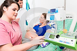 Pregnant woman in labor room with doctor and nurse photo