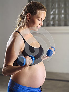 Pregnant woman doing bicep curls