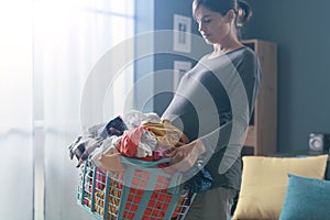 Pregnant woman doing carrying a laundry basket
