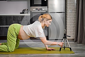Pregnant Woman Doing Cat Pose Marjariasana Exercise At Home, Watching Video Online Lesson