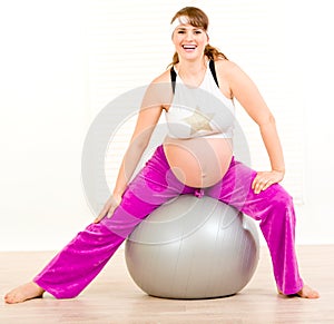 Pregnant woman doing exercises on fitness ball