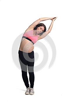 Pregnant woman doing exercises on white background