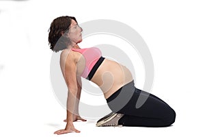 Pregnant woman doing floor exercises on white background