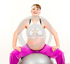 Pregnant woman doing pilates exercises on ball