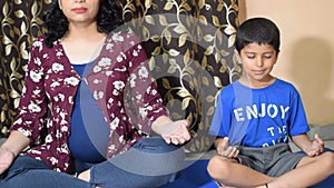 Pregnant woman doing Pregnancy yoga pose comfortable at home with her kid, Pregnant woman practicing simple yoga steps at home