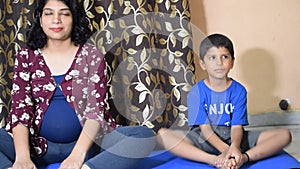 Pregnant woman doing Pregnancy yoga pose comfortable at home with her kid, Pregnant woman practicing simple yoga steps at home