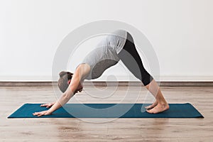 Pregnant woman doing prenatal yoga in downward facing dog posture