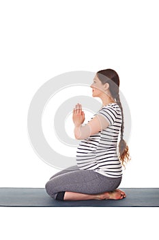 Pregnant woman doing yoga asana Virasana