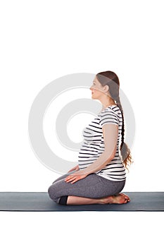 Pregnant woman doing yoga asana Virasana isolated