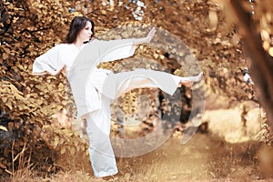 Pregnant woman doing yoga exercise in autumn