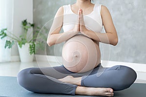 Pregnant Woman Doing Yoga On Exercise Mat. meditating for near-term childbirth of meditating attractive Pregnant female recreation