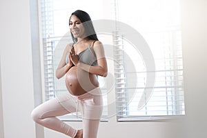 Pregnant woman doing yoga at home