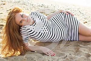 Pregnant woman in dress on beach