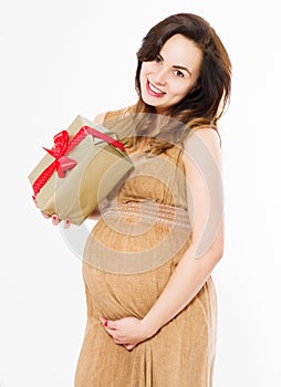 Pregnant woman in dress holds hands on belly and gift box isolated on white background. Pregnancy and maternity concept. Mother