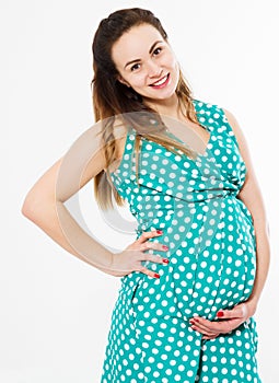 Pregnant woman in dress holds hands on belly isolated on white background. Pregnancy and maternity concept. Mother day. Copy space