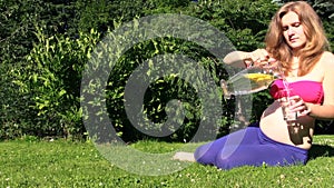 Pregnant woman drink refreshing lemon liquid in hot summer day