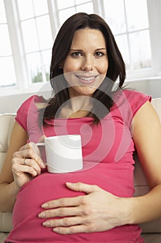 Pregnant Woman Drinking Hot Drink At Home