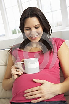 Pregnant Woman Drinking Hot Drink At Home