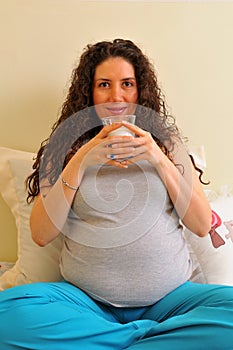 The pregnant woman is drinking milk