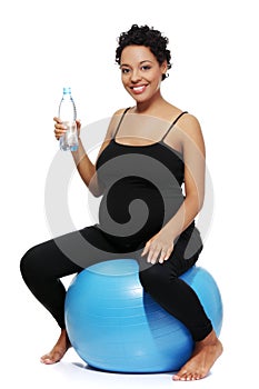 Pregnant woman drinking water during exercising.