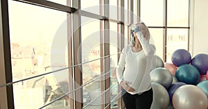 Pregnant woman drinking water in the gym