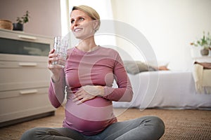 Pregnant woman drinking water.Healthy lifestyle and morning routine in pregnancy, concpet.