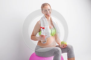 Pregnant woman drinking water after workout