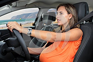 Pregnant Woman Driving a Car on Coastal Road