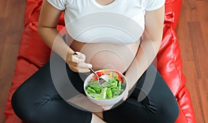 Pregnant woman eat vegetable salad, healthy food