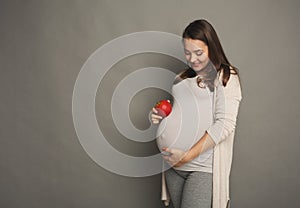 Pregnant woman eating apple at home copy space