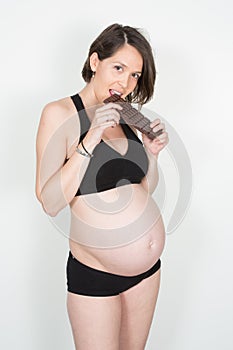 pregnant woman eating chocolate bar Healthcare, nutrition, vitamins, pregnancy concept