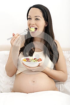 Pregnant woman eating fruit