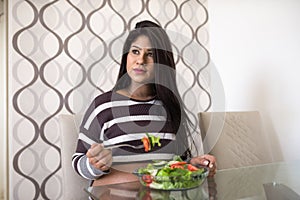 Pregnant woman eating a green salad