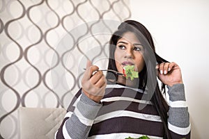 Pregnant woman eating a green salad