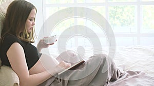 Pregnant woman eating and reading