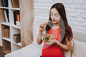 Pregnant Woman is Eating a Salad